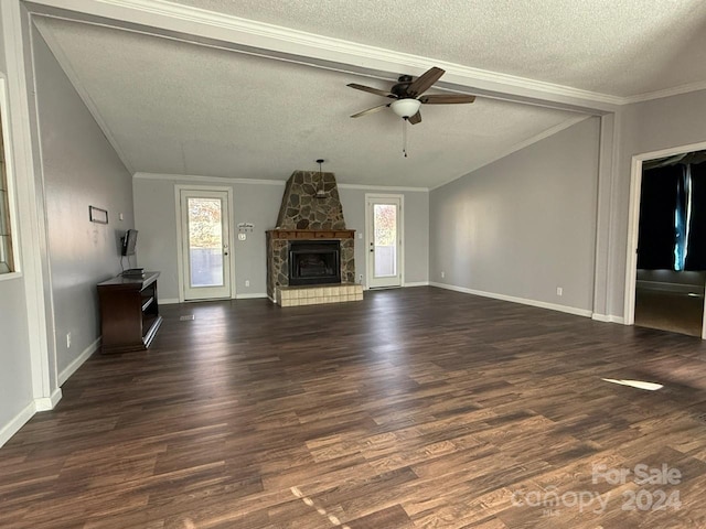 unfurnished living room featuring ceiling fan, dark wood-type flooring, crown molding, a textured ceiling, and a fireplace