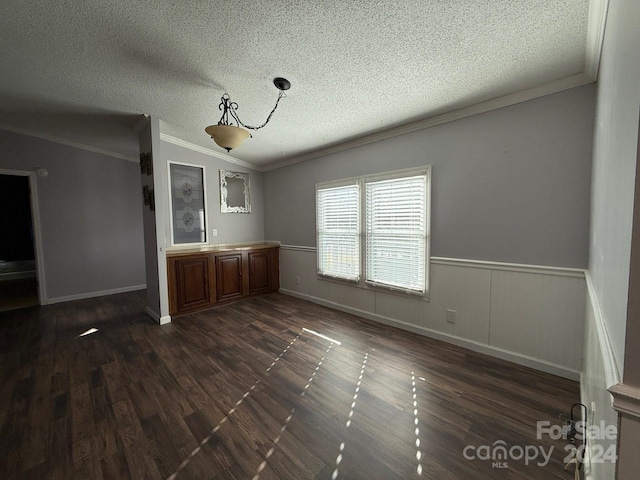 unfurnished dining area with dark hardwood / wood-style flooring, a textured ceiling, and ornamental molding