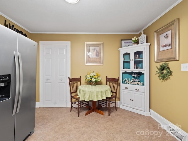 carpeted dining area featuring crown molding