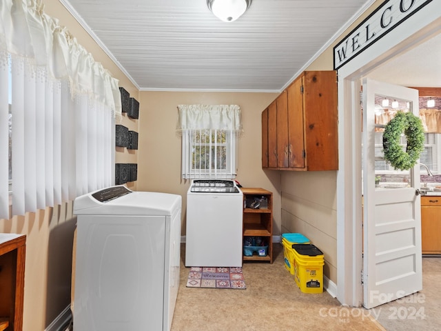 clothes washing area with light carpet, washing machine and dryer, cabinets, and ornamental molding