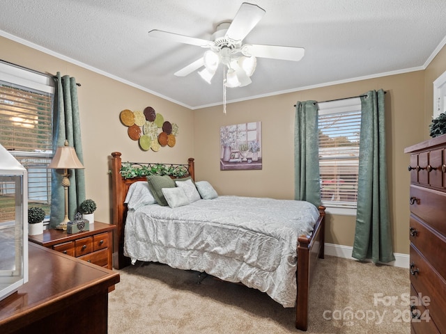 bedroom featuring light carpet, a textured ceiling, ceiling fan, and crown molding