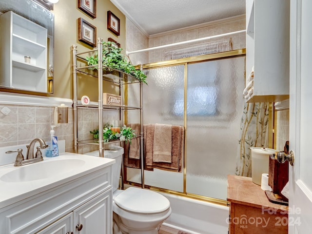 full bathroom with ornamental molding, vanity, a textured ceiling, enclosed tub / shower combo, and toilet