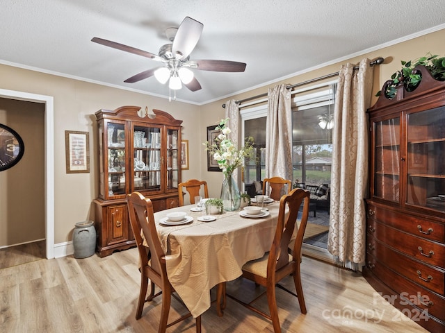 dining area featuring a textured ceiling, light hardwood / wood-style flooring, ceiling fan, and ornamental molding