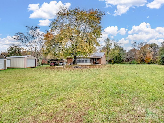 view of yard with a garage and an outbuilding