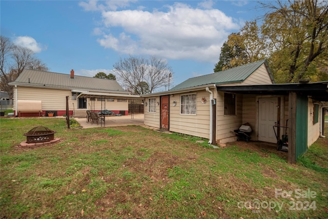 rear view of house featuring a lawn, a patio, and an outdoor fire pit