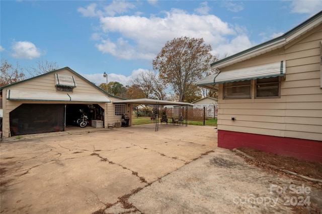 view of home's exterior with a carport, an outdoor structure, and a garage