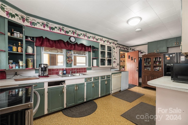 kitchen with backsplash, green cabinets, dishwasher, and sink