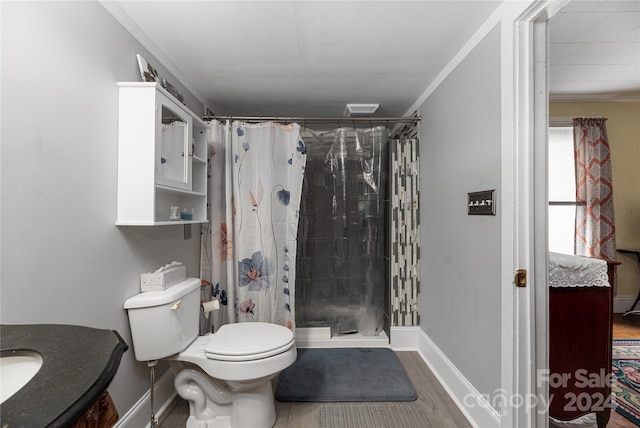 bathroom with ornamental molding, a shower with curtain, vanity, hardwood / wood-style floors, and toilet