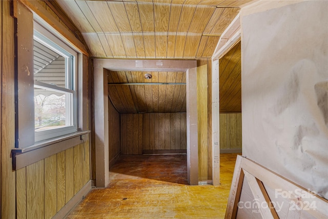 hall featuring hardwood / wood-style flooring, lofted ceiling, wooden walls, and wooden ceiling