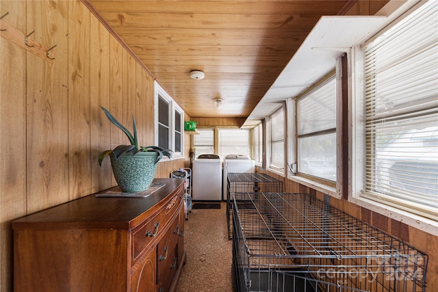 hallway featuring washing machine and clothes dryer, wooden ceiling, and wood walls