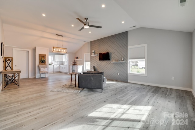 unfurnished living room with ceiling fan, vaulted ceiling, and light wood-type flooring