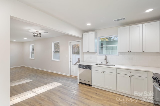 kitchen with dishwasher, sink, decorative backsplash, white cabinets, and light wood-type flooring