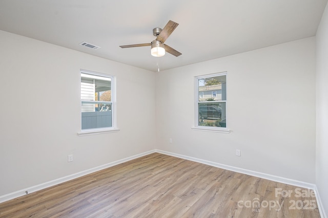 spare room with light hardwood / wood-style flooring, ceiling fan, and a healthy amount of sunlight