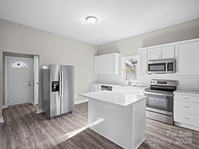 kitchen featuring a center island, sink, dark hardwood / wood-style flooring, white cabinetry, and stainless steel appliances