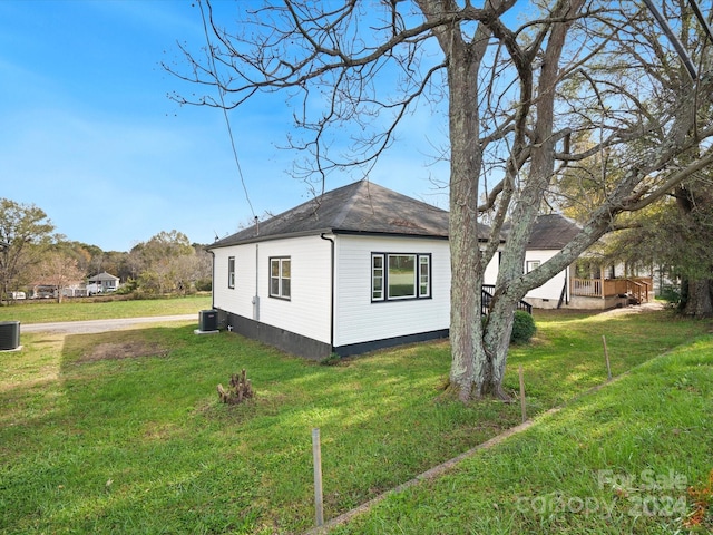 view of property exterior with a yard and cooling unit