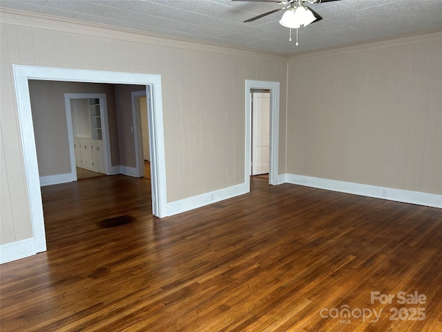 empty room featuring crown molding, dark wood-type flooring, and ceiling fan