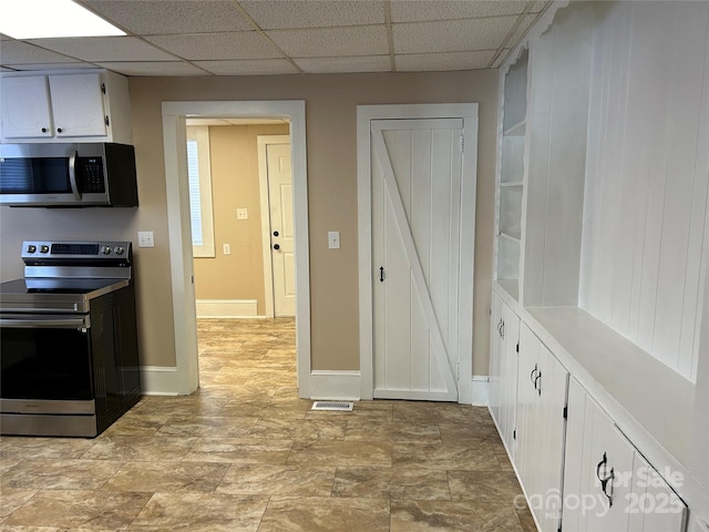 kitchen with white cabinetry, a paneled ceiling, and appliances with stainless steel finishes