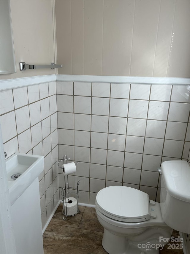 bathroom with tile walls and toilet