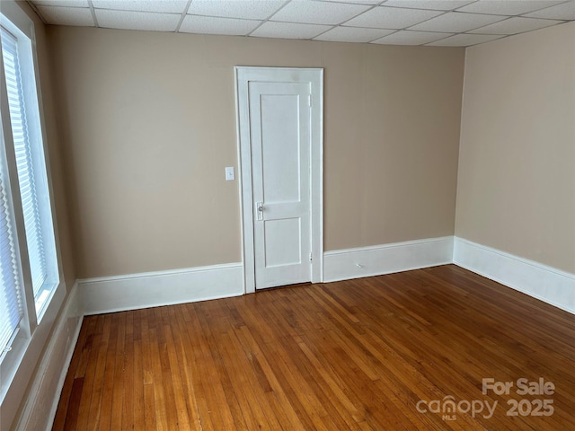 unfurnished room featuring a paneled ceiling and wood-type flooring