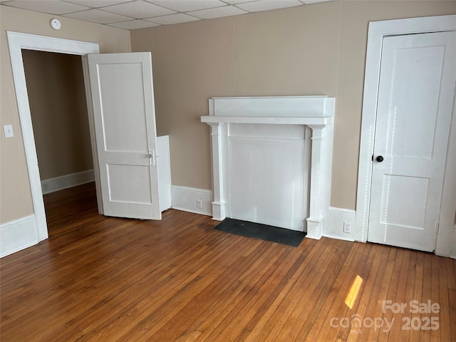 unfurnished room featuring a paneled ceiling and dark hardwood / wood-style flooring