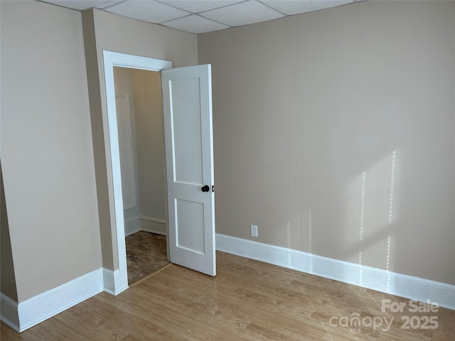 unfurnished room featuring a paneled ceiling and light hardwood / wood-style flooring