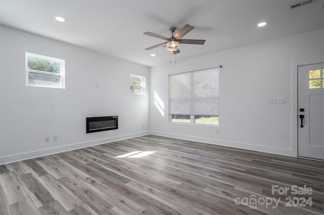 unfurnished living room with ceiling fan and wood-type flooring