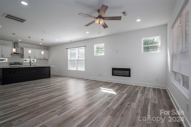 unfurnished living room featuring ceiling fan and hardwood / wood-style floors