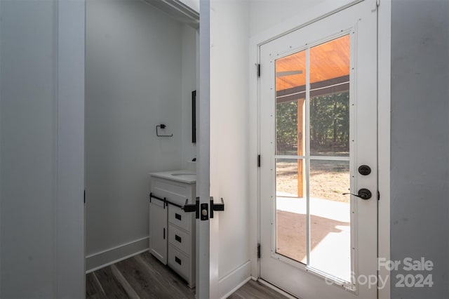 doorway to outside with dark hardwood / wood-style floors and sink