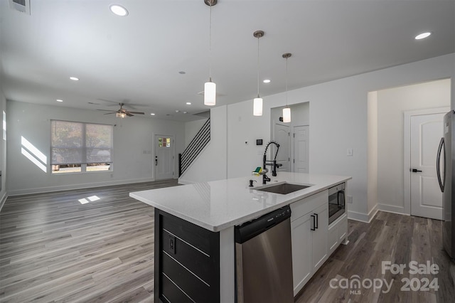 kitchen featuring white cabinetry, sink, decorative light fixtures, a center island with sink, and appliances with stainless steel finishes