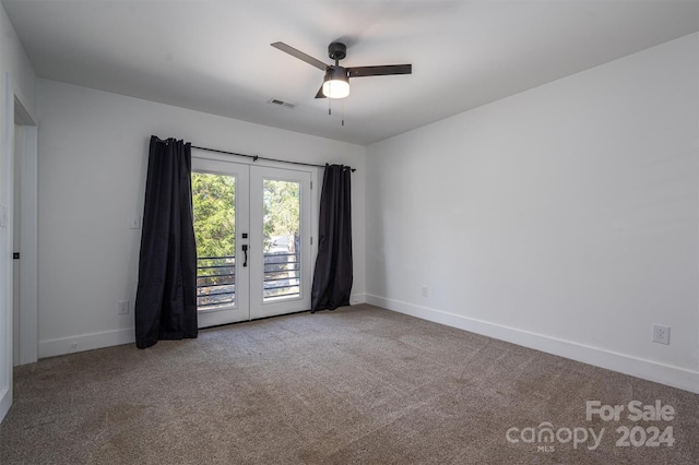 carpeted spare room featuring french doors and ceiling fan