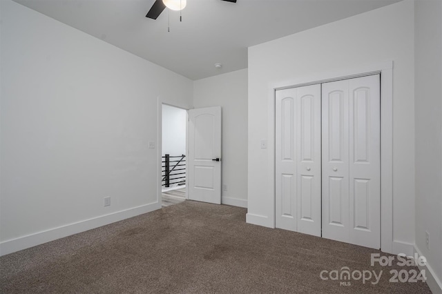 unfurnished bedroom featuring carpet, ceiling fan, and a closet