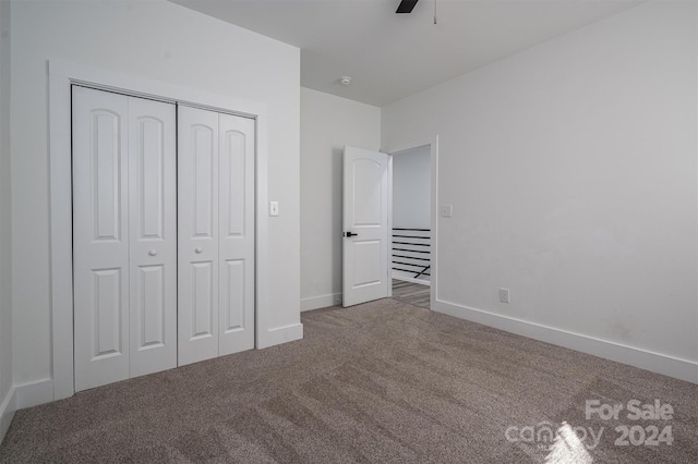 unfurnished bedroom with carpet flooring, ceiling fan, and a closet