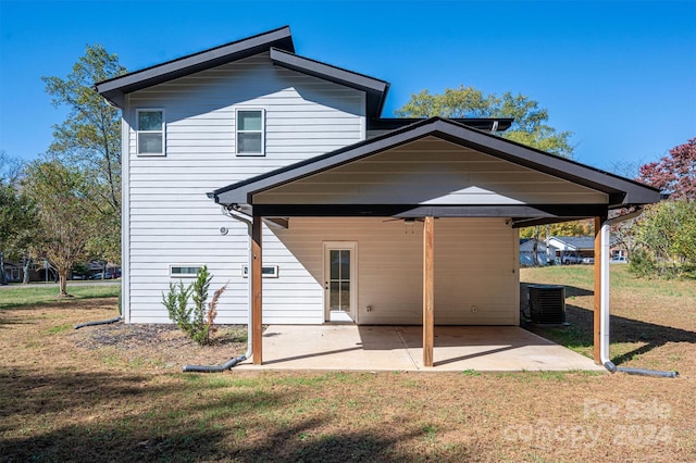 rear view of property featuring a lawn, central air condition unit, and a patio