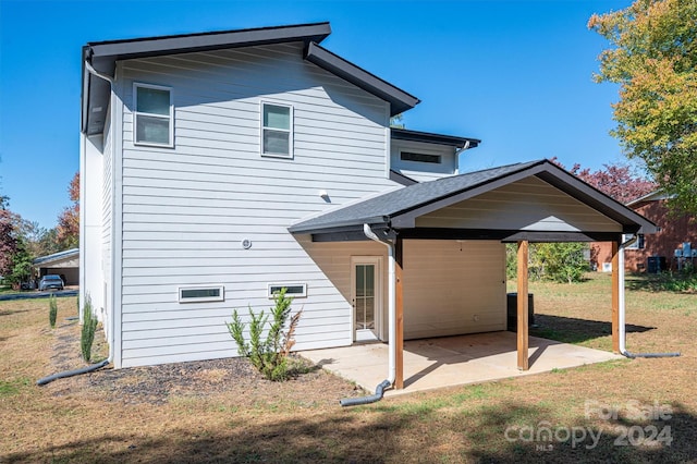 back of house with a yard and a patio