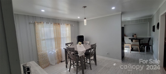 dining area with light wood-type flooring and ornamental molding