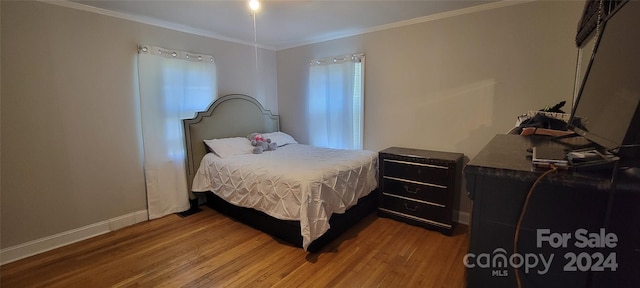 bedroom with wood-type flooring and ornamental molding