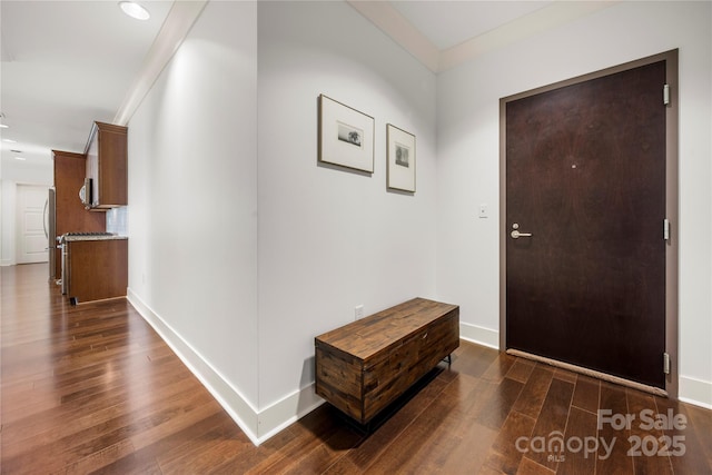 foyer entrance with dark hardwood / wood-style floors and crown molding