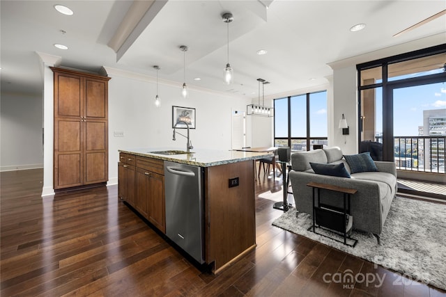 kitchen featuring dishwasher, sink, light stone counters, an island with sink, and decorative light fixtures