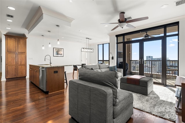 living room featuring dark hardwood / wood-style floors, floor to ceiling windows, sink, and ceiling fan