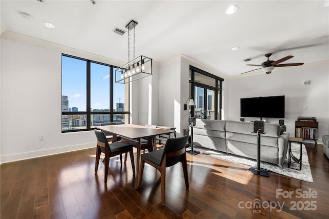 dining area featuring ceiling fan with notable chandelier, dark hardwood / wood-style floors, and ornamental molding