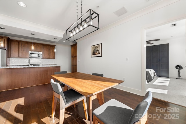 dining room featuring dark hardwood / wood-style floors, ceiling fan, and ornamental molding