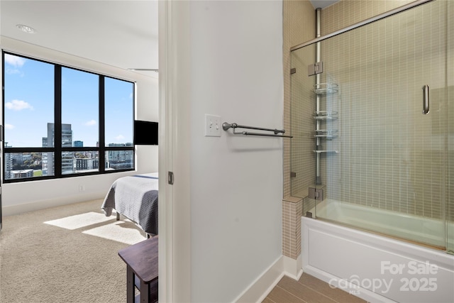 bathroom with bath / shower combo with glass door