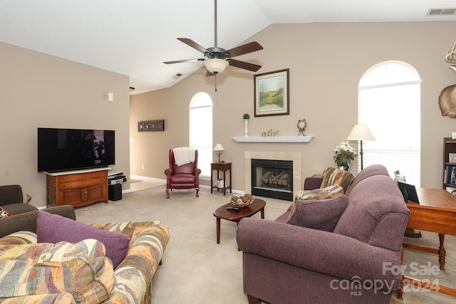 living room with ceiling fan, light carpet, a wealth of natural light, and vaulted ceiling