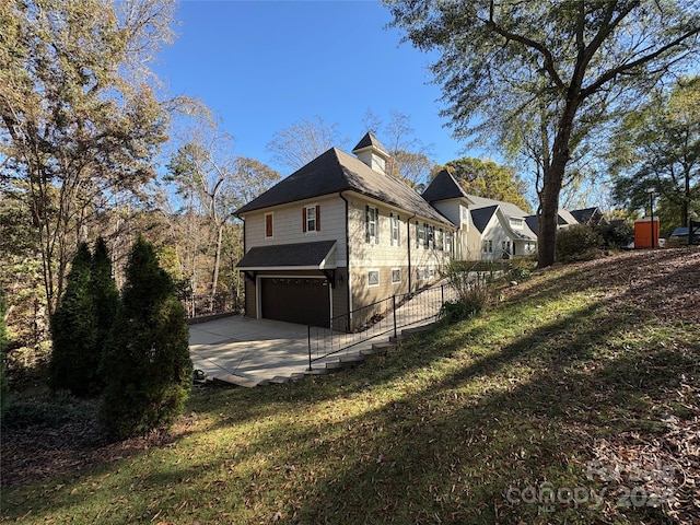 view of side of home featuring a garage and a yard