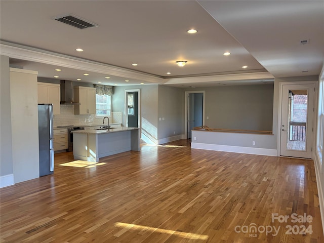 unfurnished living room with light wood-type flooring, a wealth of natural light, and sink