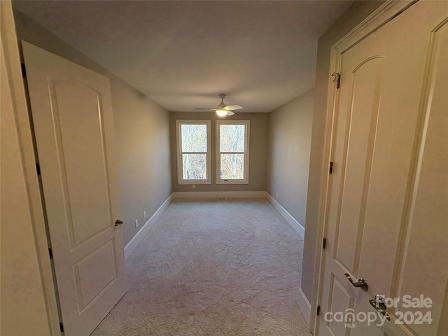 spare room featuring ceiling fan and light colored carpet