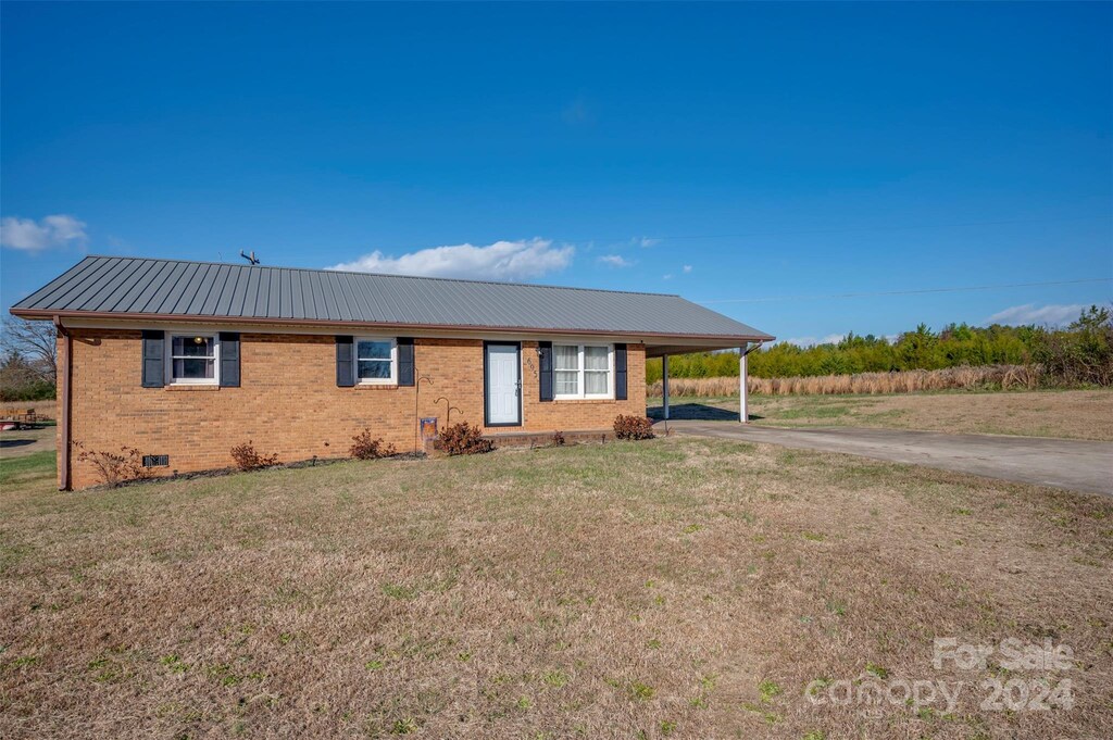 view of front of property featuring a carport and a front lawn