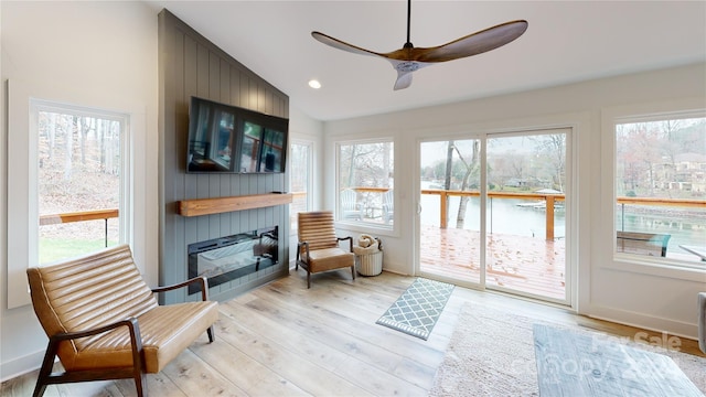 sitting room featuring ceiling fan, a healthy amount of sunlight, vaulted ceiling, and light hardwood / wood-style floors