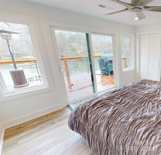 bedroom with access to exterior, light wood-type flooring, and ceiling fan