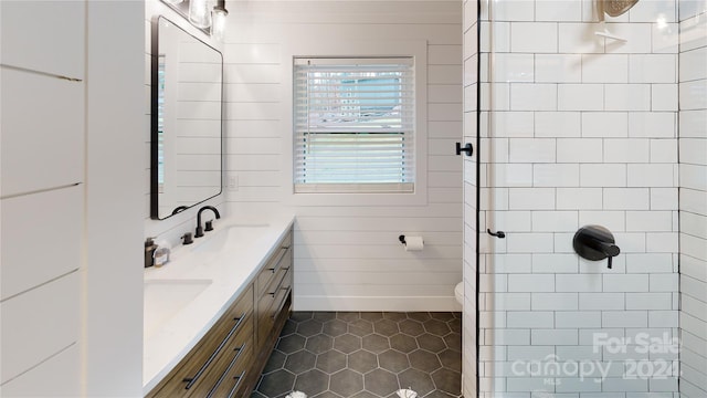 bathroom featuring tile patterned floors, wood walls, vanity, and toilet